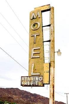 Old Motel sign ruin along historic Route 66 in the middle of California vast Mojave desert.