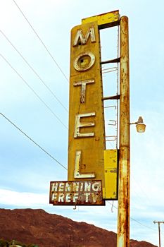 Old Motel sign ruin along historic Route 66 in the middle of California vast Mojave desert.