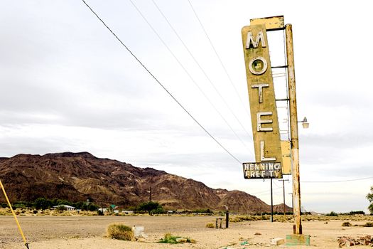 Old Motel sign ruin along historic Route 66 in the middle of California vast Mojave desert.