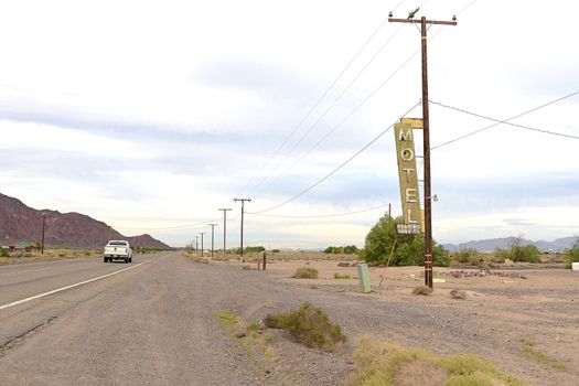 Old Motel sign ruin along historic Route 66 in the middle of California vast Mojave desert.