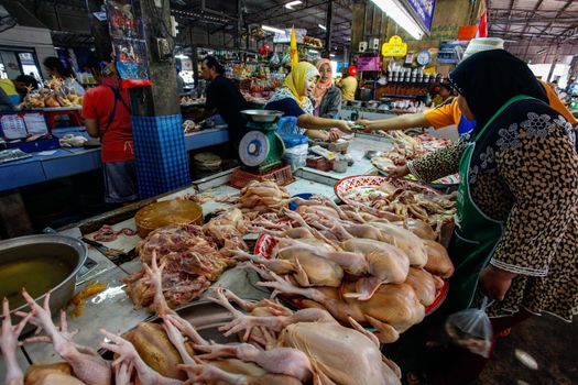 Khao Lak, Thailand - February 22, 2016:  Shoppers browsing through variety of fresh chicken legs, meat and bowels offered on local market in the morning when it's busiest.