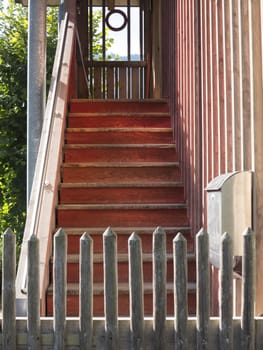 Old wooden stairway behind a fence leading upward