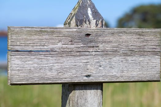 Old weathered empty wooden outdoor signpost