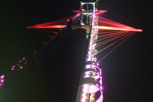 Night view of a beautiful scene of bridge over sea water in the evening time with colorful lights.