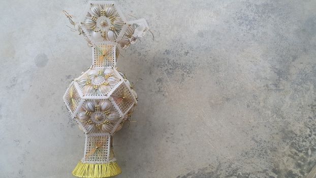 A beautiful ceramic vase placed on a grey floor. The ceramic vase has lovely designs and is used for flowers or bouquet