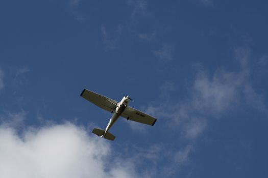 A plane flying through a cloudy blue sky. High quality photo