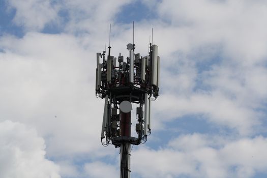 A closeup shot of a television antenna and wi-fi transmitter on cloudy sky background. High quality photo