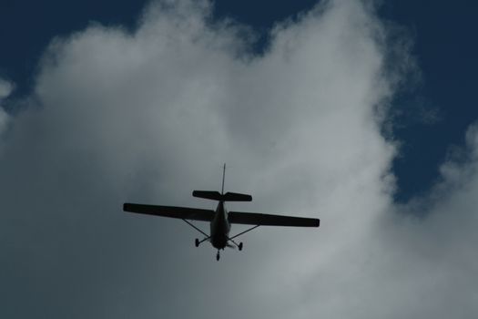 A large airplane flying high up in the air on a cloudy day. High quality photo
