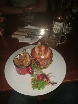 Confit pork burger with steak potatoes and mixed salad. High quality photo