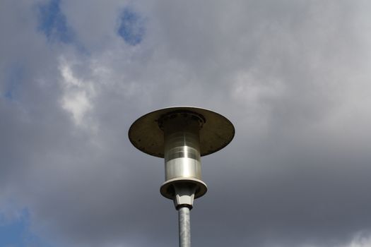 A close up of a street lamp in front of a cloudy sky. High quality photo