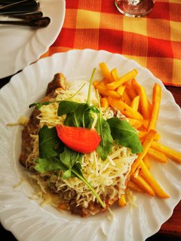 Pork ribs stuffed with cheese with french fries and mixed salad High quality photo