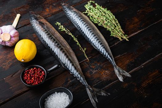 Mackerel with herbs on dark wooden background.