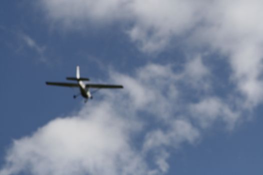 A plane flying through a cloudy blue sky. High quality photo
