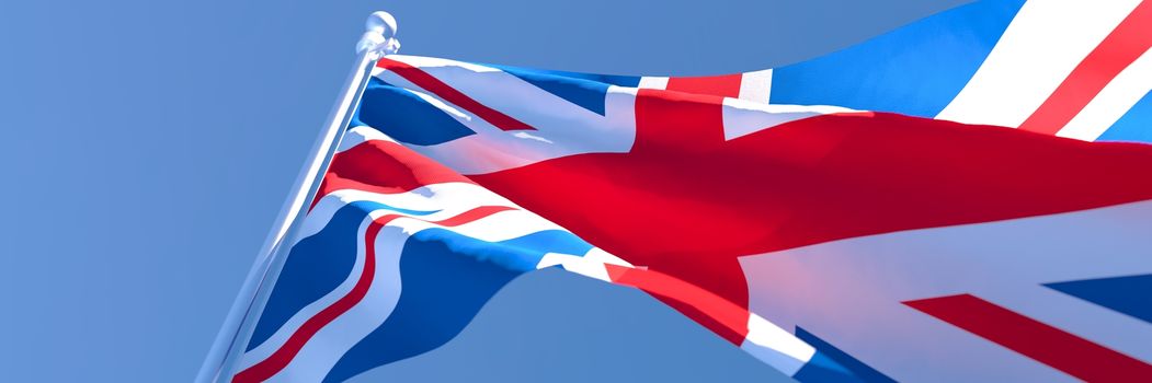 3D rendering of the national flag of British waving in the wind against a blue sky