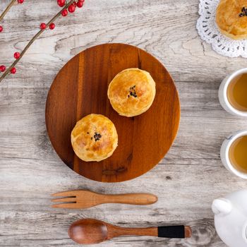 Moon cake yolk pastry, mooncake for Mid-Autumn Festival holiday, top view design concept on bright wooden table with copy space, flat lay, overhead shot