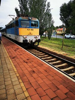 A train traveling down train tracks near a station. High quality photo