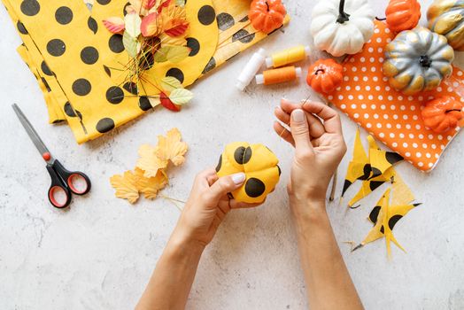 Step by step instruction of making halloween textile DIY pumpkin craft. Step 6 - use the needle and thread to divide the pumpkin into sections . Top view flat lay