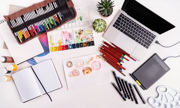 Artist or designer workspace with laptop, tablet and drawing tools top view flat lay, overhead