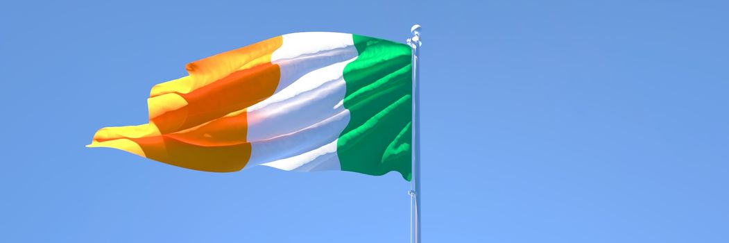 3D rendering of the national flag of Ireland waving in the wind against a blue sky