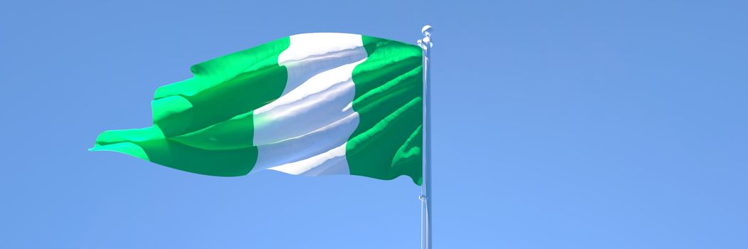 3D rendering of the national flag of Nigeria waving in the wind against a blue sky