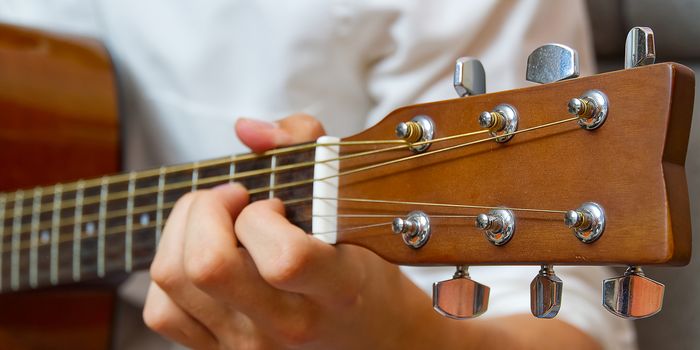 Young boy playing guitar. Close-up of man hand playing classic guitar. teenager learning playing guitar,Banner or panoramic shot.