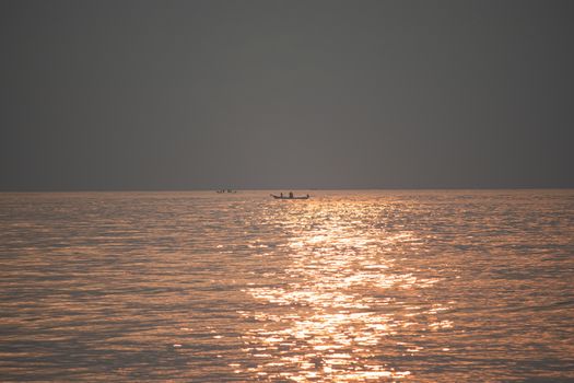 The sun's rays appear transparent in the sea water.Sunrise in the morning from the clouds at Kovalam beach in Chennai