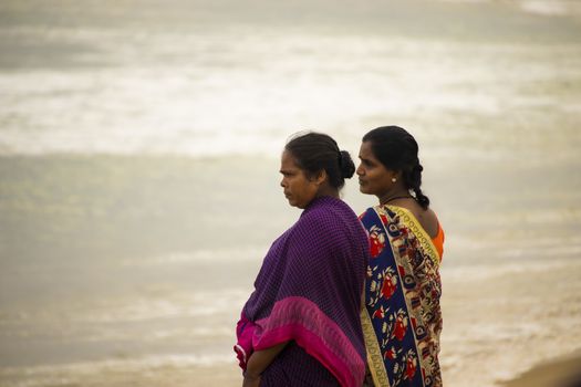 Chennai , Tamilnadu - India . September 2, 2020 . Two Tamil women watching the sunrise over Kovalam Beach