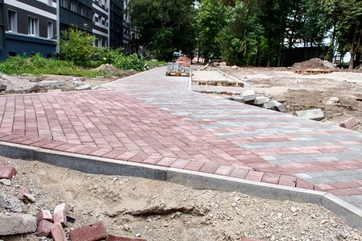 construction of a new pavement of paving slabs on summer day outdoor closeup detail