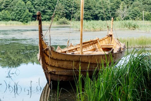 old wooden viking boat by the lake on sunny summer day