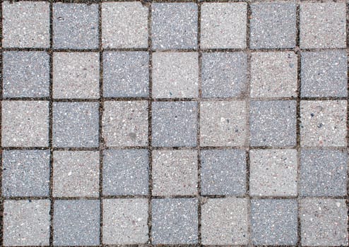 road paved with sidewalk tiles. beautiful brick background with, masonry texture of light and dark gray bricks. outdoor closeup