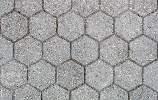 road paved with hexagonal sidewalk tiles. beautiful brick background with, masonry texture of light gray bricks. outdoor closeup