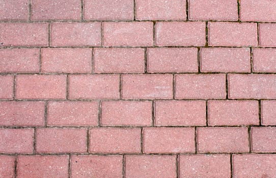 road paved with sidewalk tiles. beautiful brick background with, masonry texture of light brown bricks. outdoor closeup