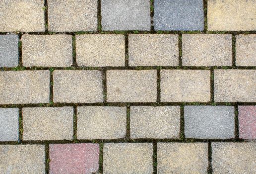 road paved with sidewalk tiles. beautiful brick background with, masonry texture of light brown, yellow and gray bricks. outdoor closeup