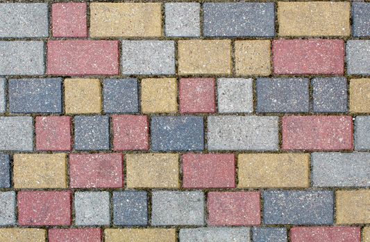 road paved with sidewalk tiles. beautiful brick background with, masonry texture of light brown, yellow and gray bricks. outdoor closeup