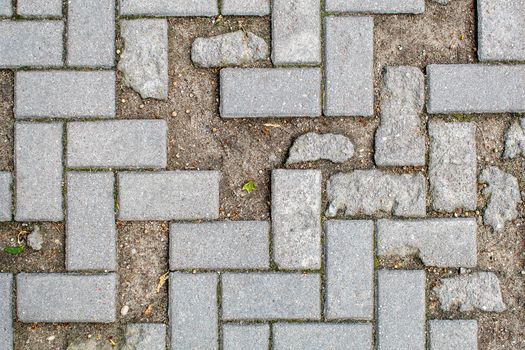 pavement with broken broken tiles. beautiful brick background with, masonry texture of light gray bricks. outdoor closeup