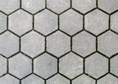 road paved with hexagonal sidewalk tiles. beautiful brick background with, masonry texture of light gray bricks. outdoor closeup