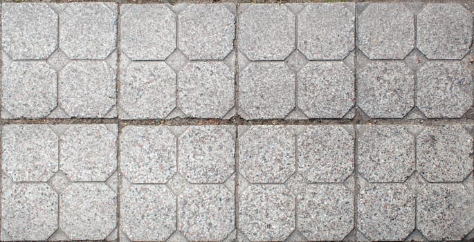 road paved with sidewalk tiles. beautiful brick background with, masonry texture of light gray bricks. outdoor closeup
