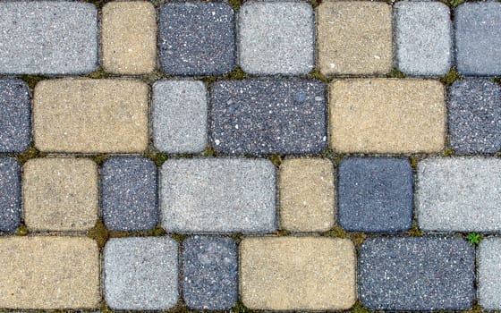 road paved with sidewalk tiles. beautiful brick background with, masonry texture of yellow light and dark gray bricks. outdoor closeup