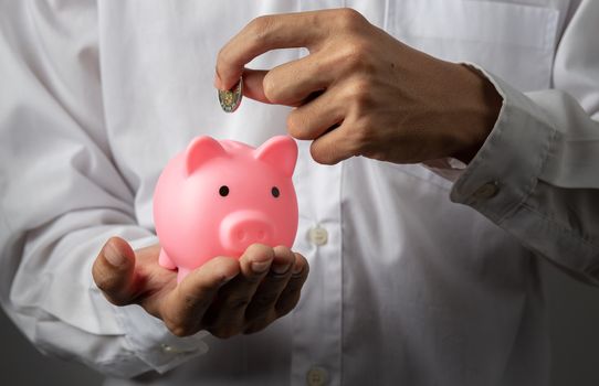 Hand of kid holding coin put in piggy bank with money stack growing growth saving money, Concept invesment for financial freedom plan, business deposit to hope success