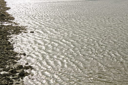 Water, stones, dike and rocks on the north German coast of Butjardingen in Lower Saxony, Germany.