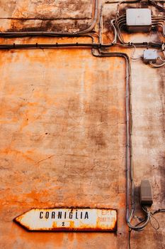 Detail on a wall of a house in Vernazza pointing to the town of Corniglia on a clear winter's day in the Cinque Terre, Italy