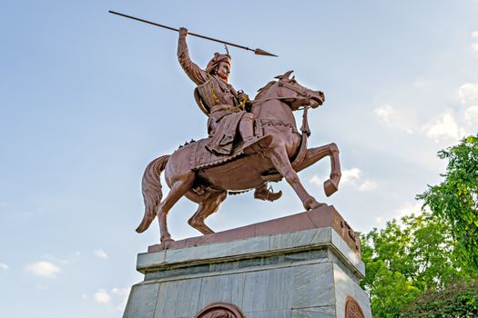 Pune, Maharashtra, India. May 26, 2016. In war action statue of Bajirao Peshwe in front of heritage structure, Shaniwarwada.