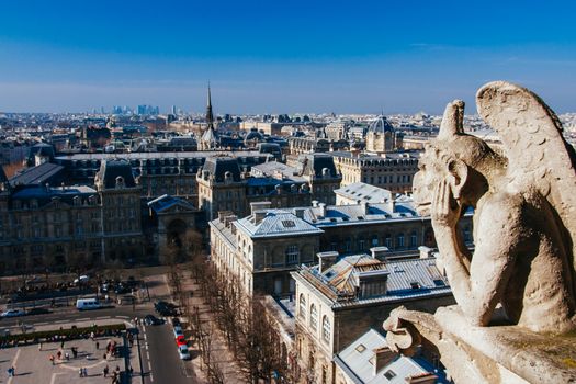 Notre Dame gargoyle detail overlooking the Paris skyline in France