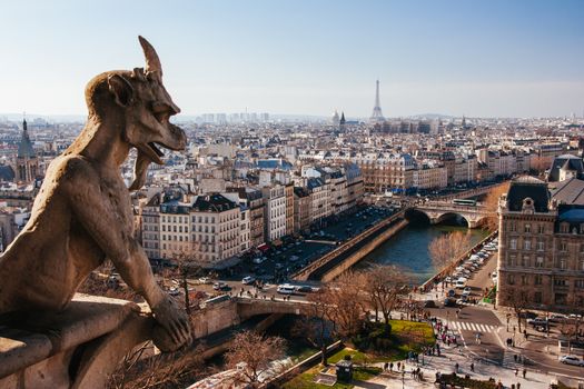 Notre Dame gargoyle detail overlooking the Paris skyline in France