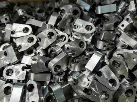 pile of shiny steel parts, full frame industrial background.