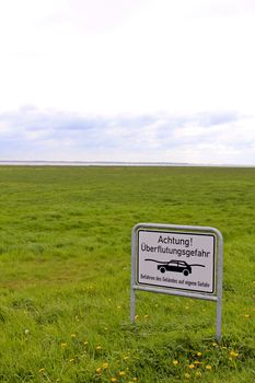 Warning, flood hazard road sign in the moor area of ​​northern Germany.