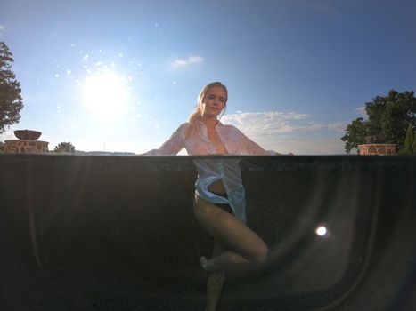 A gorgeous blonde bikini model enjoys a summers day by the pool