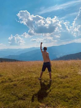 happy young man with arms raised