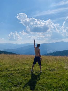 happy young man with arms raised