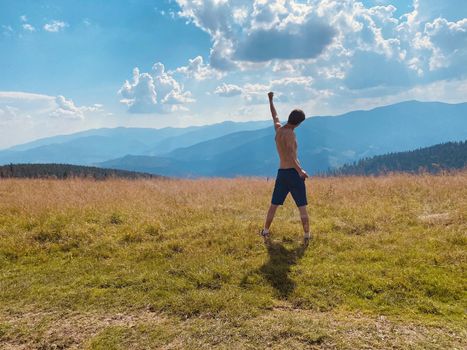 happy young man with arms raised